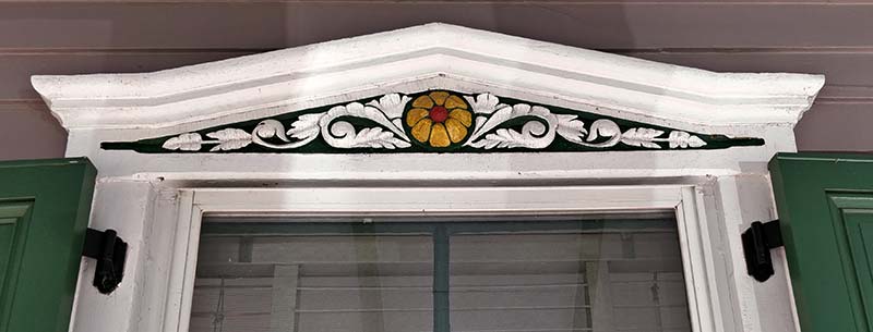 triangular window top with yellow flower and vines