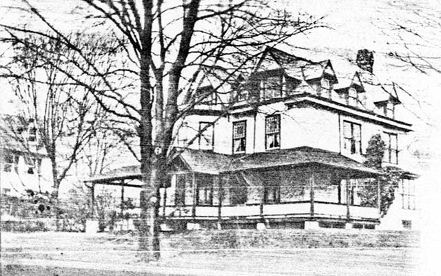 large 3-story frame house with full-width covered porch