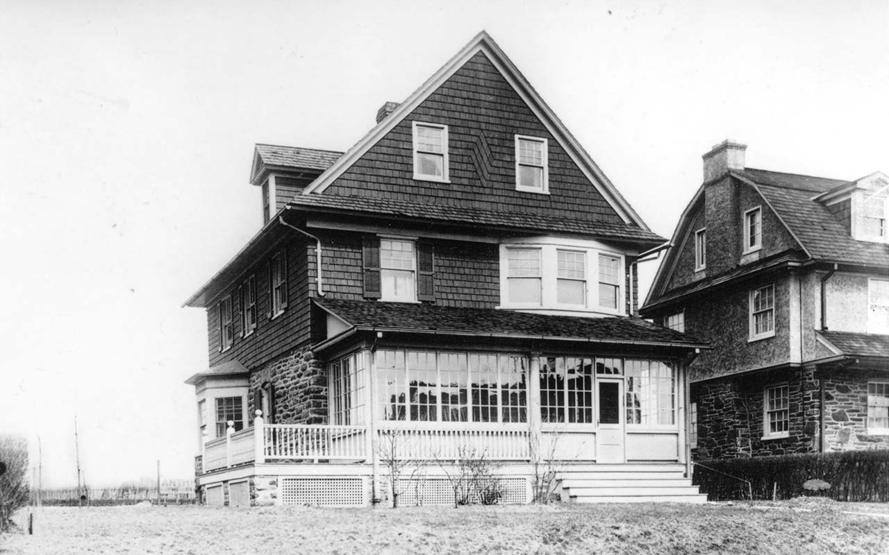 front view of a wood shingled house, stone on first story