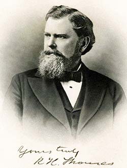 head and shoyuders photo portrait of a serious-looking bearded man formally dressed
